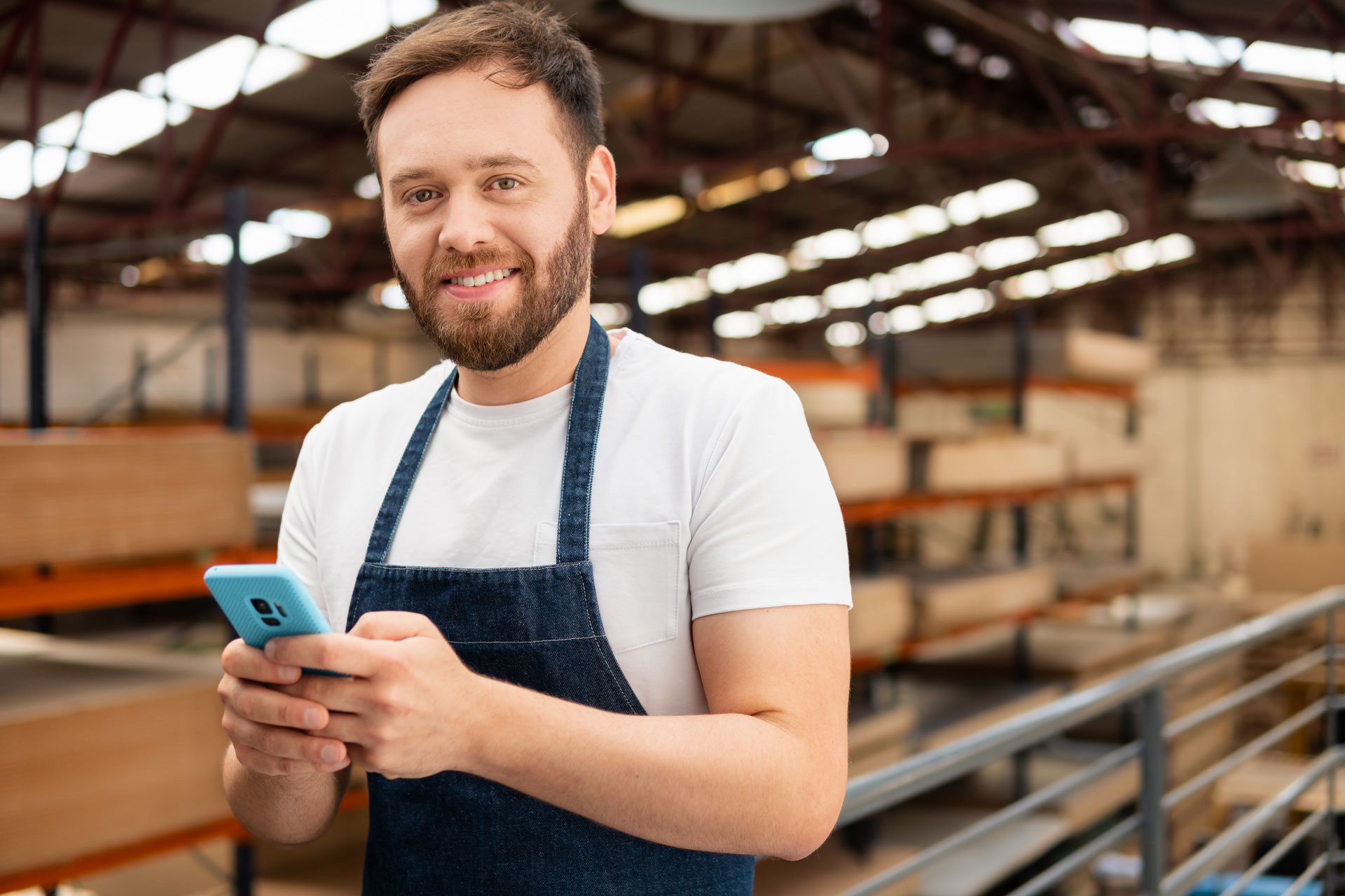 happy businessman using mobile phone to work and view request at warehouse